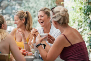 Women Sitting around Table enjoying food and company