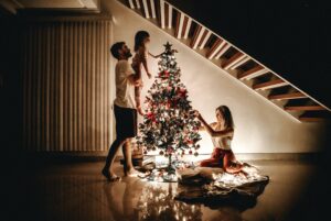 Family Decorating a lit up Christmas Tree