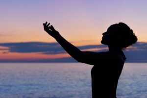 Silhouette of a women doing a yoga pose in front of a beautiful sunset